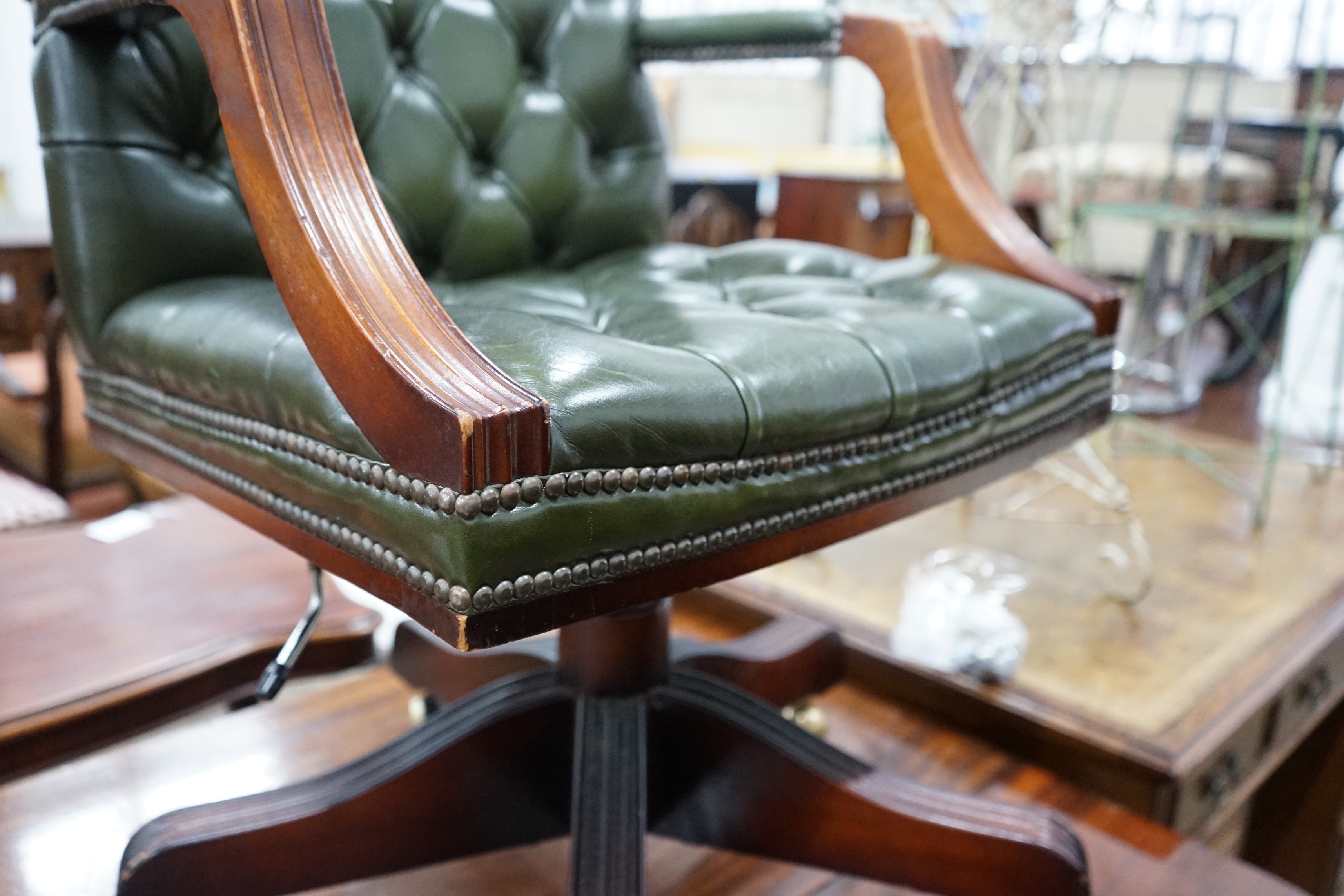 A reproduction mahogany and buttoned green leather swivel desk chair, width 56cm, depth 51cm, height 94cm